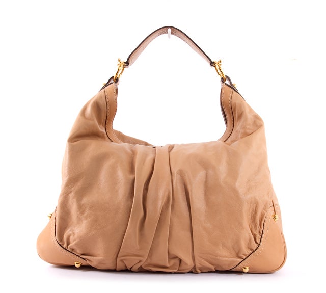This is an authentic GUCCI Large JOCKEY Hobo Leather Tan Beige Shoulder Bag. It features a signature Gucci horse-bit handle inspired by the design house's traditional equestrian style. It is done in supple beige leather with coordinating leather