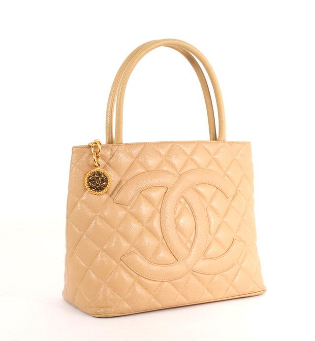 This is an authentic and simply stunning Chanel Medallion Quilted Leather Tote Bag. Done in the softest, most supple Beige Chanel Caviar leather Golden toned hardware, this tote is part of the Chanel Classics collection, and is sure to add glamour