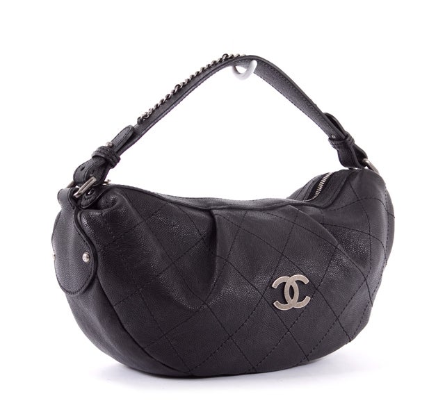 This is an authentic CHANEL Outdoor Ligne Diamond Stitch Hobo Bag. It is done in stunning black diamond stitch quilted caviar leather and features a single flat handle with chain link accents, silver toned hardware, CC hardware accents, and a simple