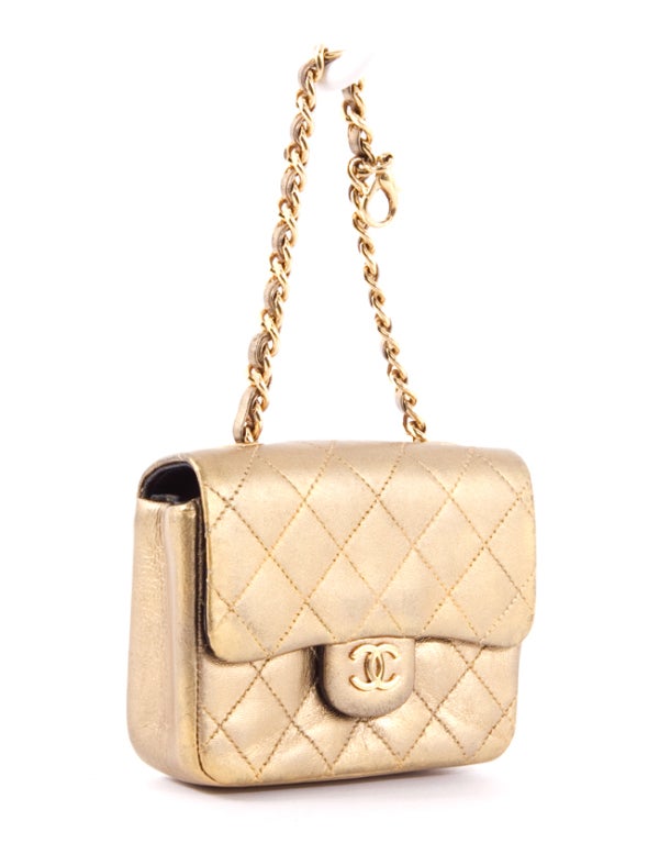 This is an authentic CHANEL Rare Leather Metallic Gold Mini Classic Quilted Belt Bag. This little beauty is a mini version of Chanel's signature flap bag. It is done in a stunning metallic gold and features a flap with snap closure, an exterior back