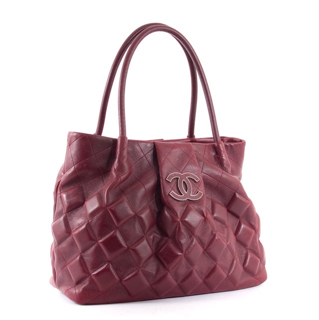 This is an authentic CHANEL Large Burgundy Sloane Square Tote Bag. It is done in lovely burgundy leather with stitch quilted accents. There are dual rolled handles, silver-Toned hardware, and a small flap closure. The spacious interior is done in