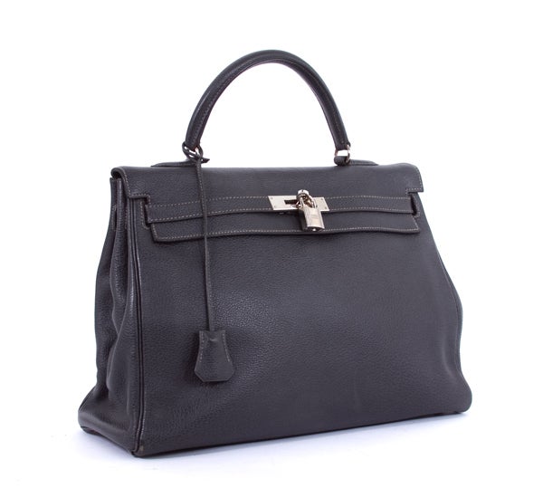 This is an authentic HERMES Graphite Buffalo Kelly 35 cm Palladium Hardware Bag. It is done in gorgeous dark graphite toned leather with silver hardware. It features a single rolled leather handle and the signature Hermes flap top closure with