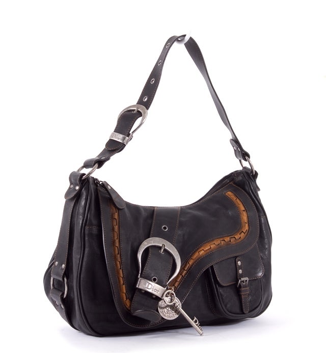 This is an authentic Christian Dior Gaucho bag. Done in black distressed leather with light brown leather details and silver hardware, this bag is highly sought after by Dior lovers everywhere. This bag features double flat leather shoulder straps