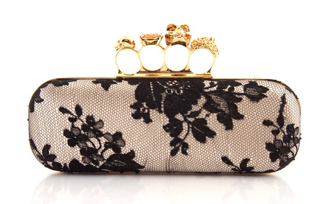 This is an authentic Alexander McQueen Satin and Lace Knucklebox Clutch. This bag features delicate champagne colored satin with a black lace overlay, which is contrasted with bold gold toned hardware and Swarovski crystal rings. The clasp closure