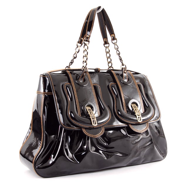 This is an authentic Fendi Black Patent Leather Large Classic B Bag. The bag patent leather exterior is showcased with gold stitching and brushed gold-toned hardware. The front features two large buckle accents that compliment the chain link and
