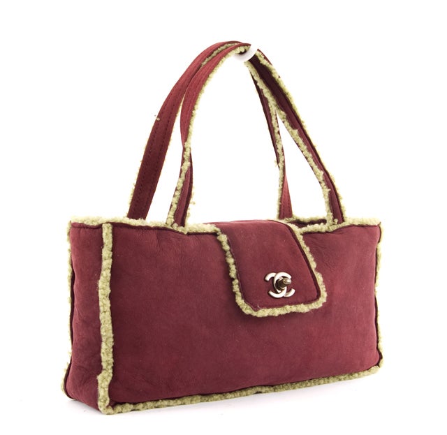 This is an authentic Chanel Plum and Kiwi Suede Shearling Purse. This bag is constructed of supple plum suede with light green trim. The center clasp closure features the classic double Cs in sophisticated graphite toned hardware. This bag is the