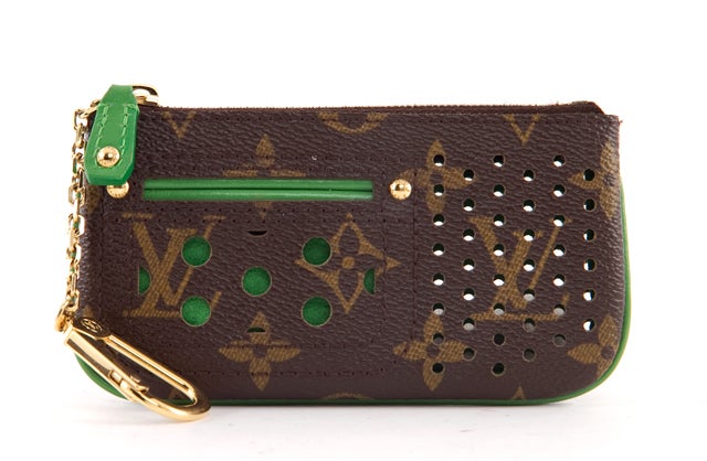 This is an authentic LOUIS VUITTON Perforated Green Monogram Key Cles Coin Holder Wallet. This item is the classic Key Cles Coin Holder with a twist! It is done in perforated LV monogram canvas and features a lime green leather trim and interior. It