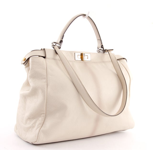 This is an authentic FENDI Large Beige Goatskin Leather PEEKABOO Handbag Purse. This lovely bag features amazing beige goatskin leather and both silver and gold hardware. The bag has a clasp closure and opens on both sides. The bag interior is done
