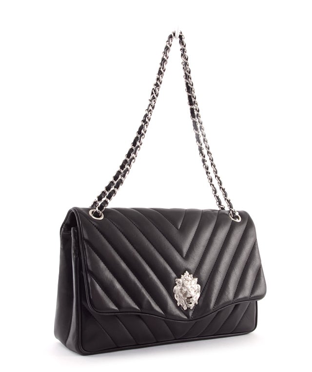 This is an authentic CHANEL Leo Flap Chevron Lion Clasp RARE Bag. It is done in absolutely gorgeous quilted leather with elegant silver toned hardware. It features a long (double) chain and leather entwined shoulder strap as well as a signature