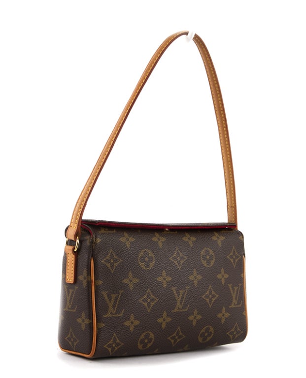 This is an adorable and guaranteed authentic Louis Vuitton Recital Bag. Done in traditional Monogram Canvas, the Recital's compact design makes it a fabulous day-to-evening purse. It features a rounded leather strap in vachetta leather and has