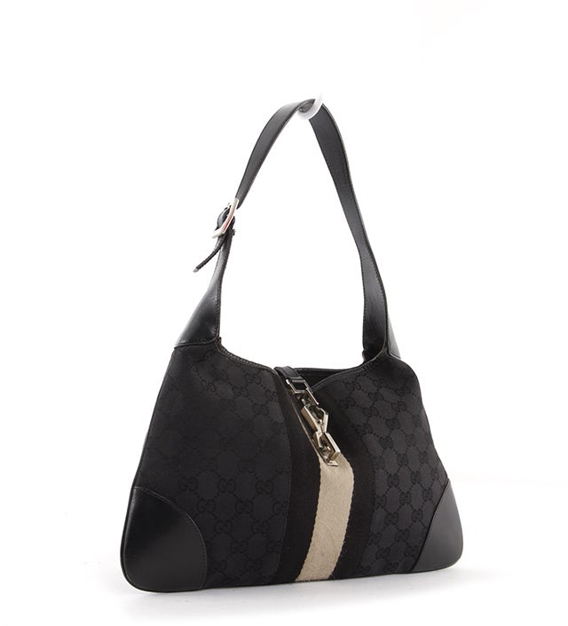 This is an authentic GUCCI Classic Jackie O Hobo Monogram Striped Black Shoulder Bag. It is done in signature Gucci Guccissima monogram canvas with silver tone hardware and a black and cream colored stripe down the center. It features a single flat