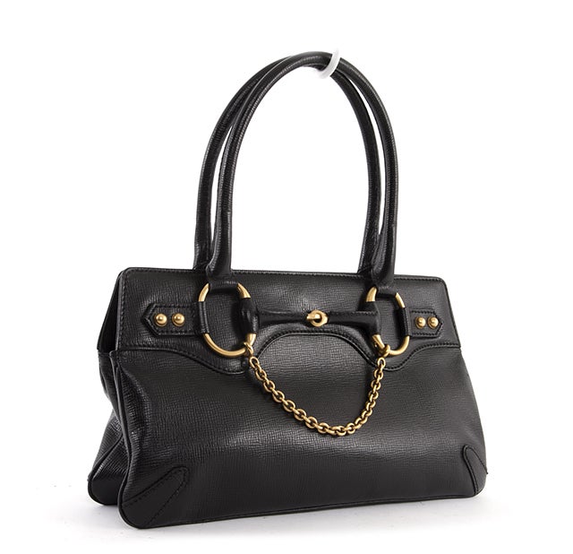 This is an authentic Gucci Black Leather Horsebit Bag. Done in Gucci black textured leather, it has fantastic Horsebit golden toned hardware accents at the bottom and front (interlocking Gucci Horsebit and Chain, studs). The bag has a zip top