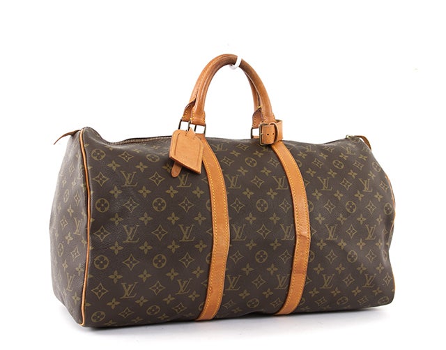 This is a guaranteed authentic Louis Vuitton Keepall 50 Bag. Done in classic LV signature Monogram Canvas material with leather trim and golden hardware, this authentic Louis Vuitton carryall is a classic. The interior is lined in a brown textile