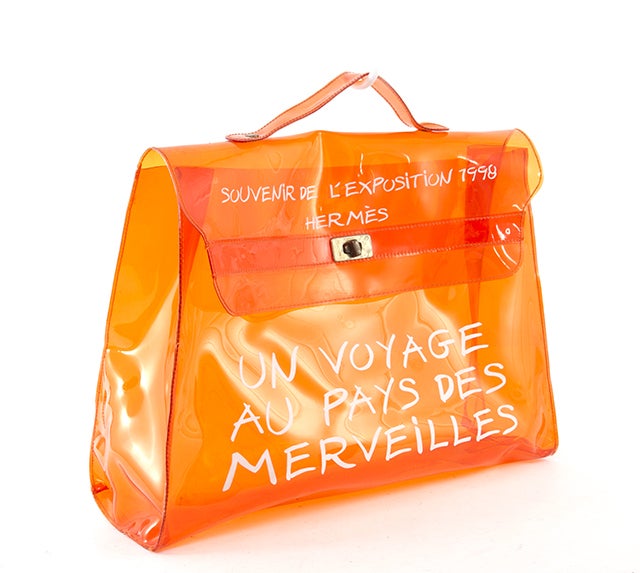 This is an authentic HERMES Orange Vinyl Travel Beach VOYAGE Kelly Bag. It is done in eye popping orange vinyl with gold hardware. This beach tote features a single vinyl handle, a flap over and kiss lock closure, and an inscription that reads