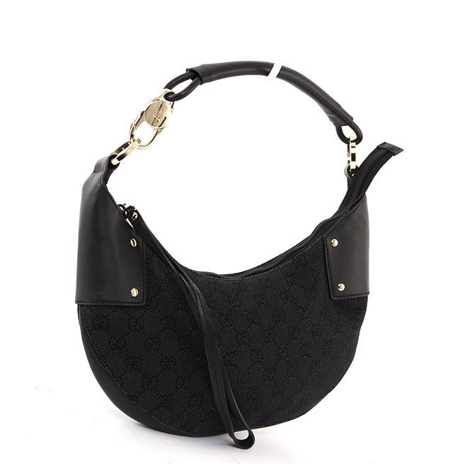 This is an authentic GUCCI Monogram GG Black Crescent Hobo Bag. Done in Gucci monogram denim, this bag features black leather trim, pale gold hardware and hardware accents, a simple zip closure, and a single shoulder strap. The interior is done in