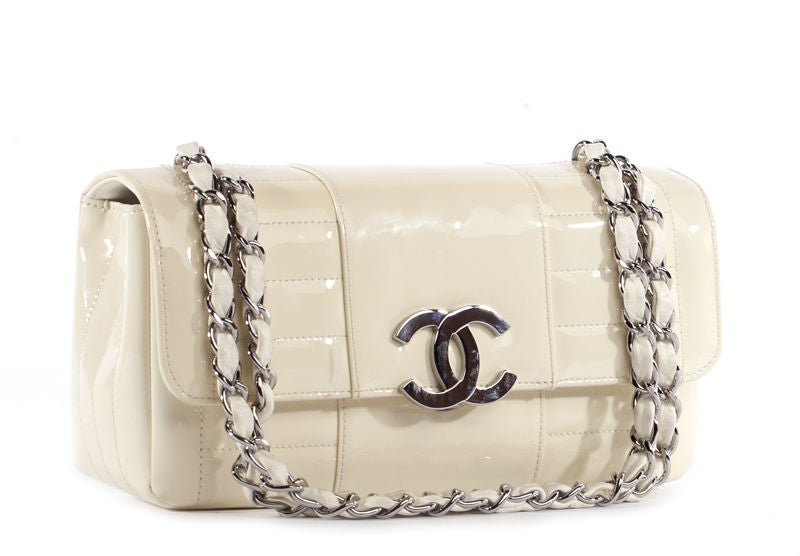 This is an authentic CHANEL Ivory Patent Leather Cube Quilted Flap Bag. It is done in beautiful glossy cube quilted white patent leather with elegant silver toned hardware. The bag features two chain and leather entwined handles and a flap top with