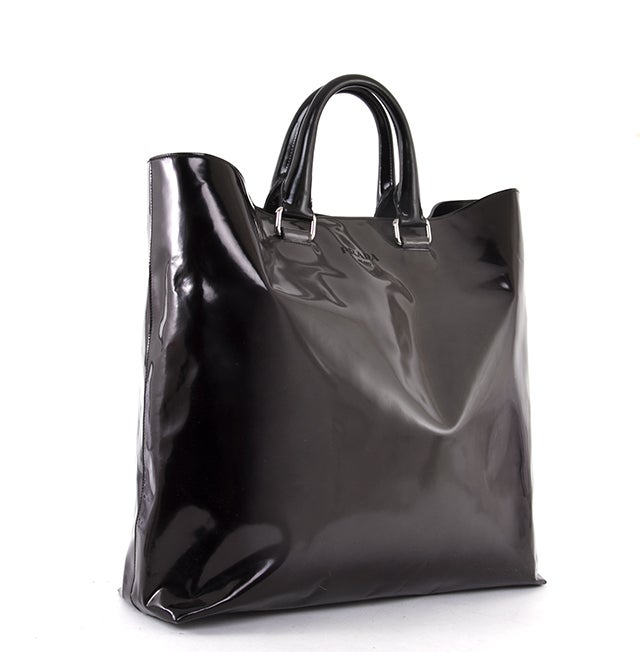 This is an authentic PRADA Shopper Tote. This unique beauty is done in a grey and black, two-toned patent and features dual rolled handles. The roomy interior is done in coordinating black Prada textile and includes two side compartments for