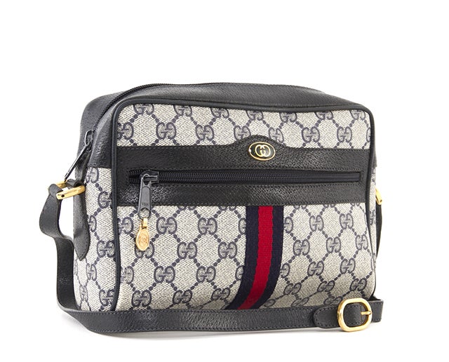 This is an authentic Gucci Vintage Monogram Crossbody Bag. This bag is done in a signature navy Gucci GG print canvas with gold tone hardware, a simple zip closure, and an exterior zipper pocket and navy pebbled leather trim. It also features a long