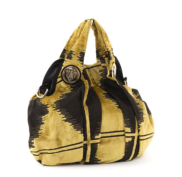 This is an authentic Gucci Bag. Done in a unique black and gold abstract design. The flat structure features two flat handles, gold-toned hardware, d-ring shoulder strap attachments, and a snap closure. The interior is lined in black Gucci textile