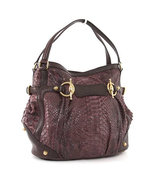 This is an authentic Gucci Bag. This unique bag is done in lovely mauve colored croc textile with gold-toned hardware and leather trim. The bag features two flat handles, hardware stud and horsebit accents, side buckle adjusters, and a partial flap