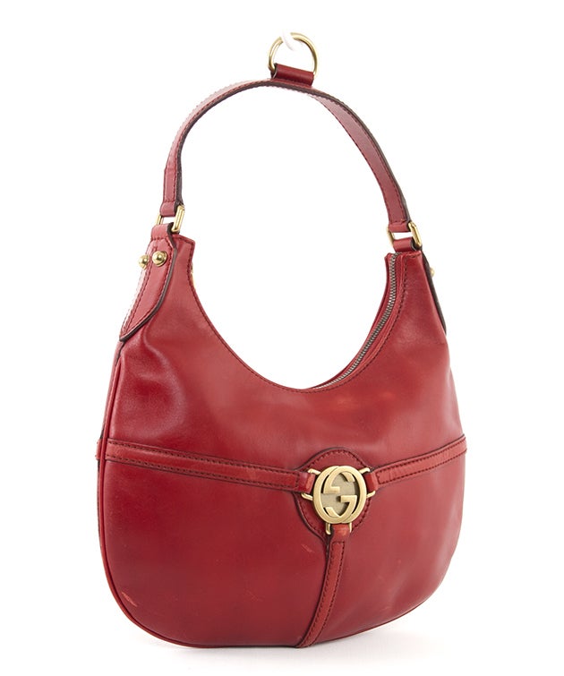 This is an authentic Gucci Bag. Done in lovely red leather, this bag features leather trim, gold hardware, a single flat handle, a simple zip closure and a Gucci hardware emblem. It has a flat structure. The interior is done in a coordinating red