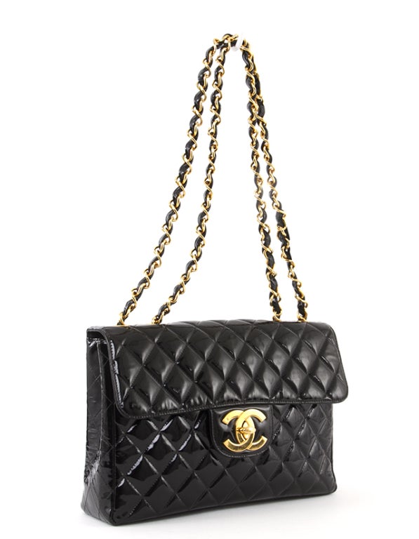 This is an authentic Chanel Bag. It is done in shiny quilted black patent leather with elegant gold-toned hardware. The bag features two chain and leather entwined handles and a flap top with kisslock closure. The interior is lined in classic black