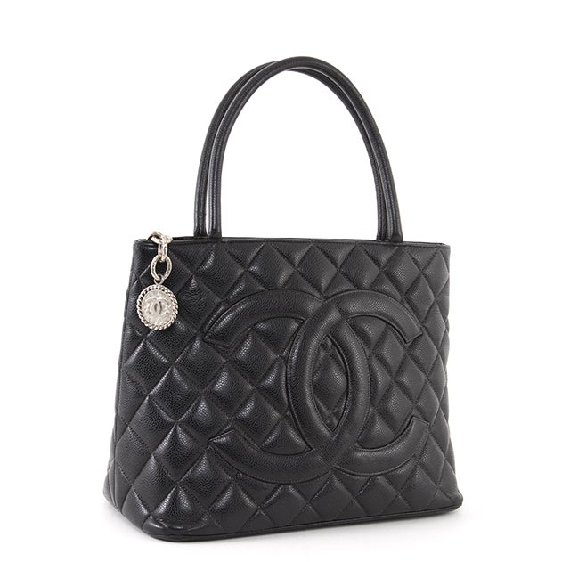This is an authentic CHANEL Caviar Medallion Black Bag. It is done in classic Chanel caviar leather, featuring the signature Chanel Medallion zipper pull.  The exterior is supple and soft with one flat pocket on the backside of the bag. The interior