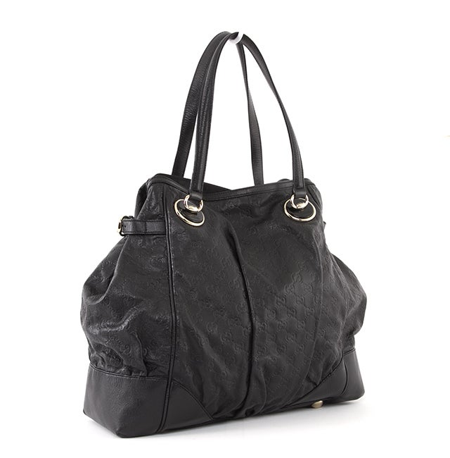 This is an authentic Gucci Bag. It is done in signature Gucci Guccissima black leather with smooth black leather trim and gold-toned hardware. The bag features two flat leather handles, a rounded top and a flat bottom with four protective feet. It