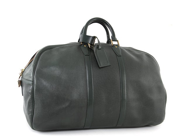This is an authentic Louis Vuitton Kendal Taiga Leather Travel Bag. It is done in lovely forest green signature Louis Vuitton Taiga leather with smooth leather trim and gold tone hardware. It features two rolled handles as well as a detachable
