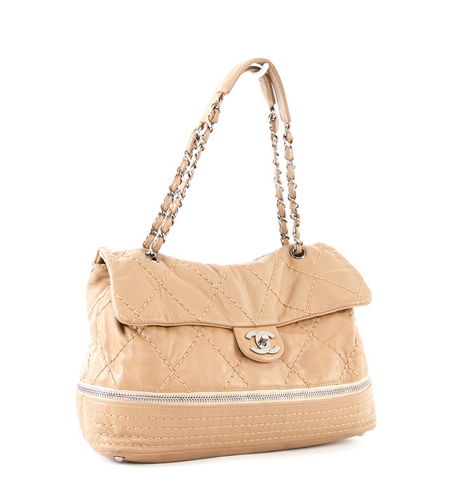 This is an authentic Chanel bag. It is done in supple beige leather with diamond stitched accents and silver-toned hardware. This unique bag features a zip around base that allows for bag expansion. It also features a flap with CC turn-lock closure