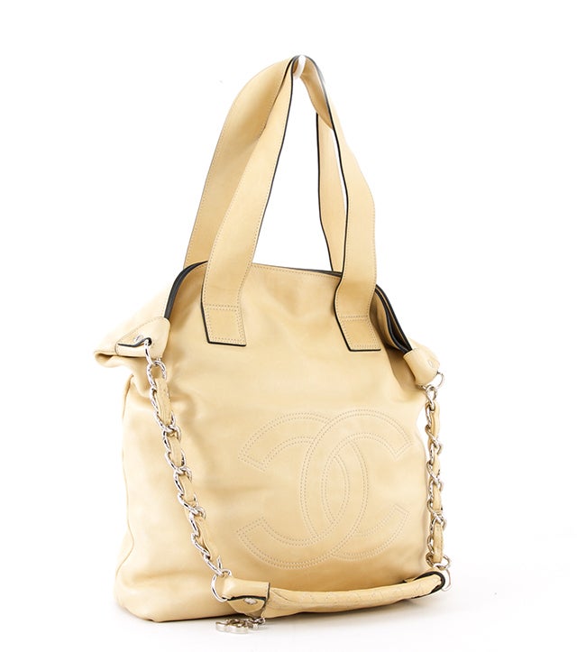 This is an authentic Chanel Edgy Tote bag. This bag is done in supple beige leather with silver-toned hardware. It features a large CC interlocking logo on the front exterior, dual flat handles and a single shoulder strap with zipper pouch, and a