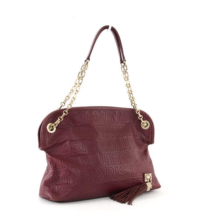 This is an authentic Souple Whisper PM bag by Louis Vuitton. This unique beauty is done in stunning burgundy leather with large 