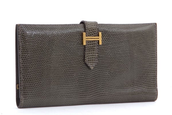 This is an authentic HERMES Bearn Wallet in Lizard Skin. This is a fantastic Hermes clutch wallet with functionality for everyday, yet a most sophisticated style to it. The wallet is in the lovely Hermes Gris Fonce color. It is done in elegant