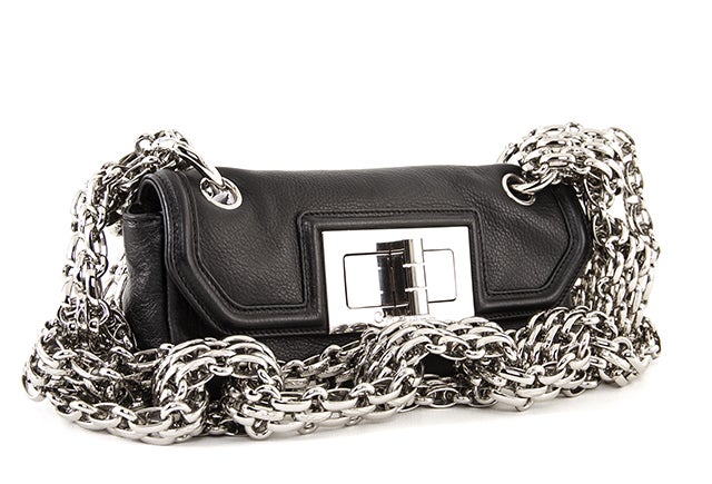 This is an authentic Chanel Mademoiselle Mini Flap Bag. Made from supple black lambskin, this small bag makes a huge statement! It features an oversized silver-toned Mademoiselle lock and chunky jewelry, bijoux chain shoulder strap. There is