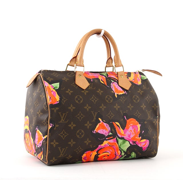 This is an authentic Louis Vuitton Stephen Sprouse Roses Speedy 30 Bag. It is done in signature Louis Vuitton monogram canvas with Stephen Sprouse's bright orange, pink, green, and black roses on the exterior. This bag features comfortable dual