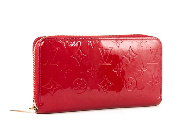 This is an authentic Louis Vuitton Vernis Zippy Wallet. Roomy enough to fit your money AND your phone, this organizer is the perfect nighttime clutch or daytime wallet! This wallet is done in rich cherry red monogramed Vernis, accented with shiny