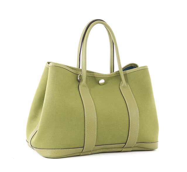 This is an authentic Hermes Garden Party tote. Made from green canvas with coordinating green leather rolled handles and base, this is the perfect casual bag for the sophisticated lady. The snap closure is silver-toned and there is the option for a