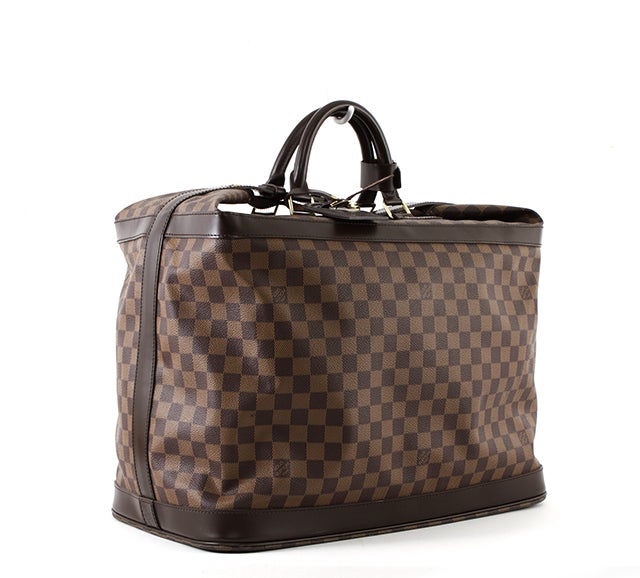 This is an authentic Louis Vuitton Cruiser Bag. Done in gorgeous Damier Ebene Canvas, this bag is a handheld travel bag perfect for weekend getaways and long weekends. The bag features double rolled leather carrying handles, a textile lined interior