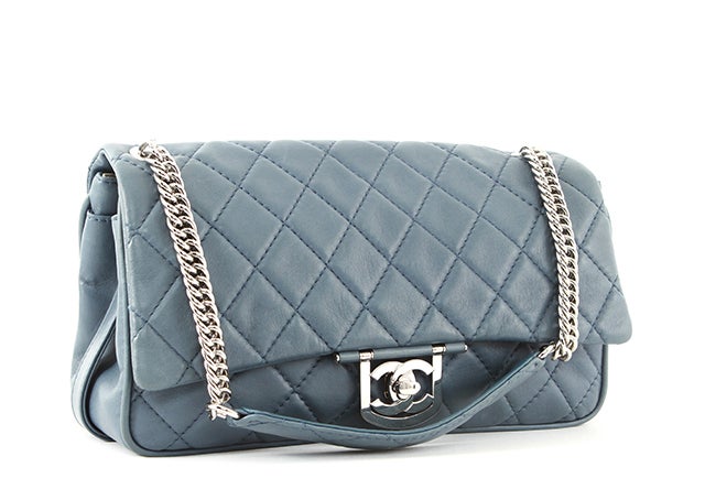 This is an authentic Chanel bag. Done in buttery grey-blue lambskin, this bag is a gorgeous addition to your handbag collection. The bright silver-toned hardware is elegant against the muted leather. This bag bears a flat pocket on the back side,