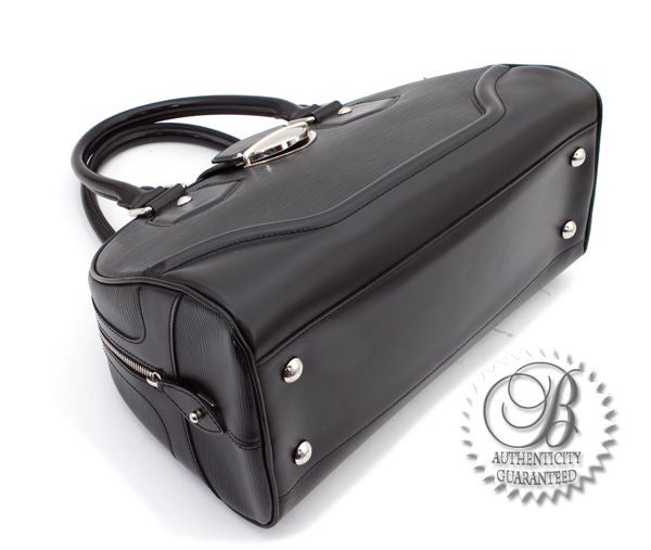 This is an authentic Louis Vuitton Black Epi Montaigne Bowling GM Bag. It is done in durable, yet elegant black epi leather, with sophisticated silver hardware, and sleek, smooth black leather handles and trim. The interior is lined in fine black
