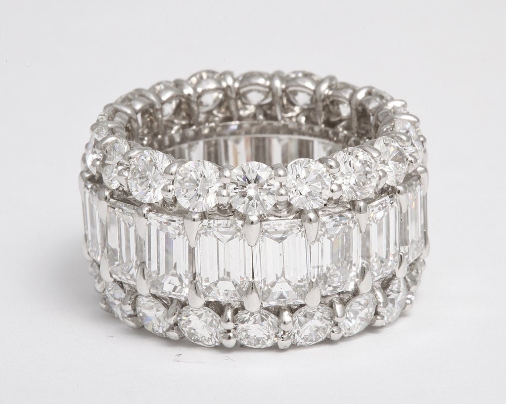 Three row diamond band featuring 36 round diamonds on the outer rows, 5.42 carats and 18 emerald cut diamonds in the center row, 8.70 carats, in platinum. 
Color F
Clarity VS