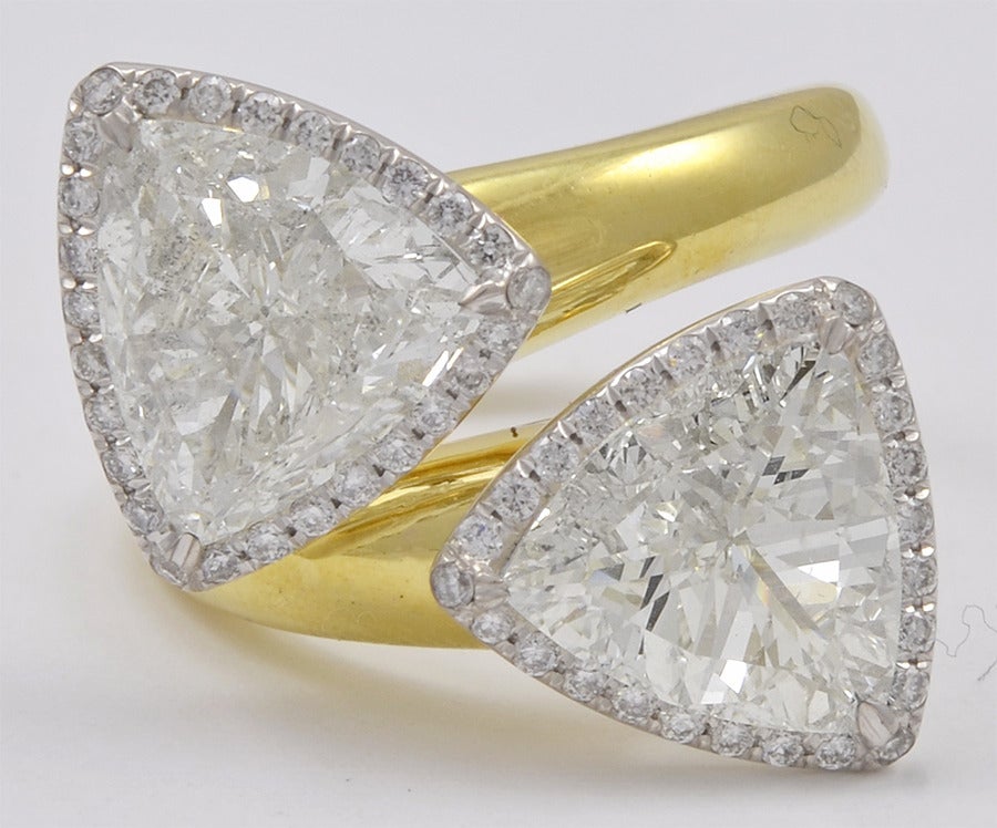 Bold Diamond Trilliant bypass ring weighing a total of 2.77 cts flanked with numerous diamonds, in 18k yellow gold