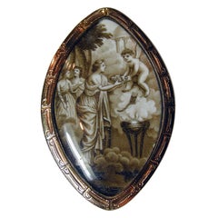 Broche ancienne d'amour sépia représentant Cupidon portant des fleurs sur une jeune fille, sous cristal