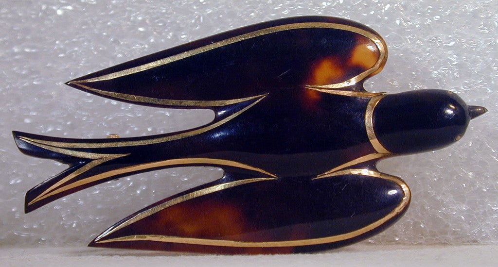 The dove of peace soars through the skies. Made of pique, tortoiseshell inlaid with gold, this charming brooch can rest on your shoulder or perch on your lapel.