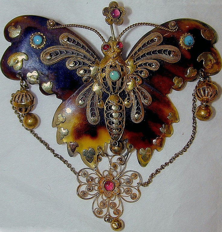 Elaborado broche de mariposa de carey decorado con filigrana de oro engastada con turquesas y granates. Estas raras piezas probablemente influyeron en el diseño de la joyería de piqué de finales del siglo XIX.