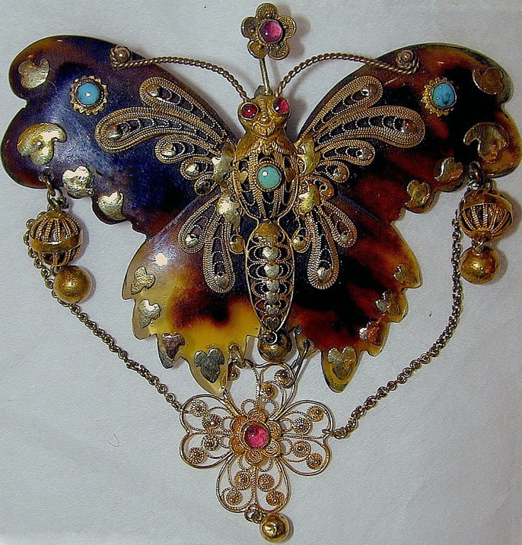 Elaborate tortoiseshell butterfly brooch decorated with gold filigree set with turquoise and garnets. These rare pieces likely influenced the design of pique jewelry of the late 1800's.