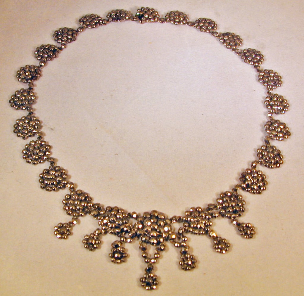 Elegant round plaques of cut steel embellish this collar, wearable day or night. Cut steel jewelry is said to have started in Woodstock, England where it evolved from the craft of constructing steel toys. It became popular as an alternative to