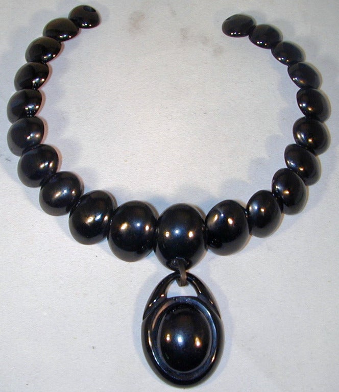 Dramatic Whitby jet necklace with a large drop, ties with a ribbon so the length can be adjusted. Jet, a fossil of carbonized driftwood, was mined at Whitby, Yorkshire, beginning in the late 1700's. The drop measures 1 1/2