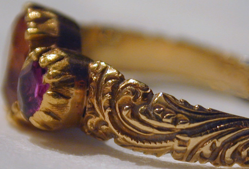 Georgian topaz ring flanked by two rubies in a carved 18K yellow gold setting will enliven your hand worn alone or stacked with other rings. The ring is a size 7 1/2.