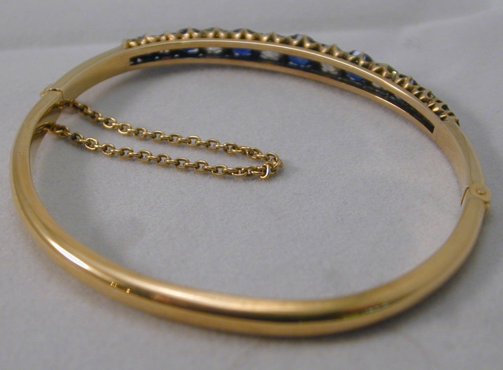 This beautiful Victorian 18K bangle is set with 7 natural sapphires having a total weight of 2.45 cts and 8 cushion cut diamonds with a total weight of 2.7 cts. Very wearable.